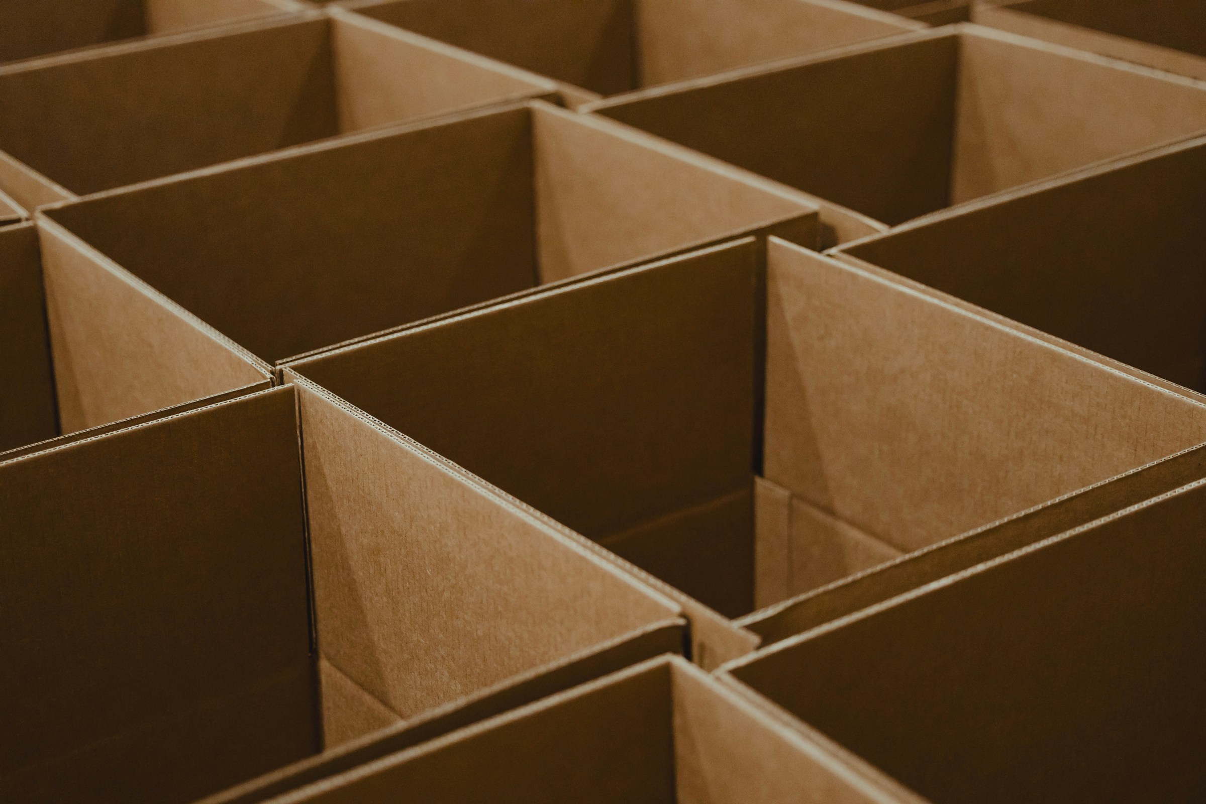 A bunch of open brown cardboard boxes stacked